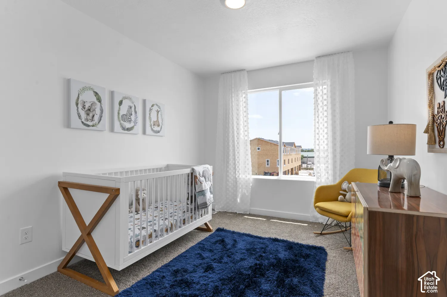 Carpeted flooring, a large window, and a built-in overhead light fixture