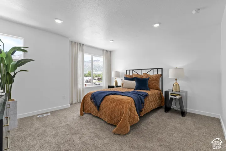 Recessed lighting, light gray carpeting, and multiple windows with white trim