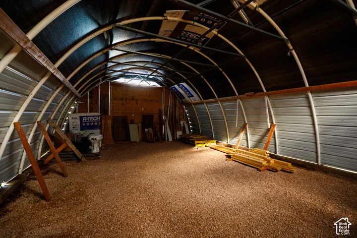 Arched metal frame structure with corrugated metal siding and a gravel floor