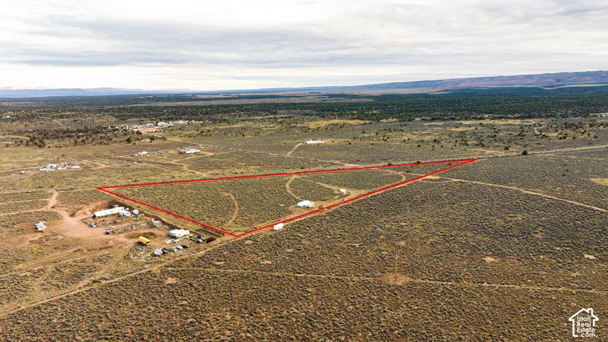 Expansive land parcel with defined boundaries, featuring distant natural landscapes