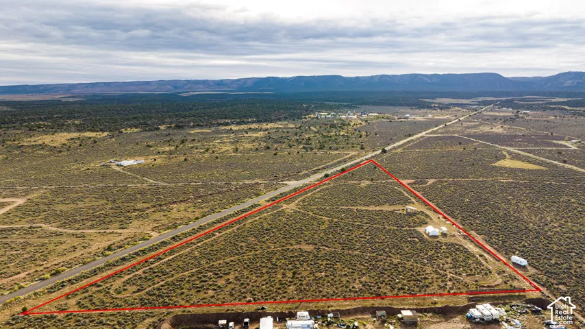 Expansive desert landscape with a defined perimeter, featuring a paved road frontage