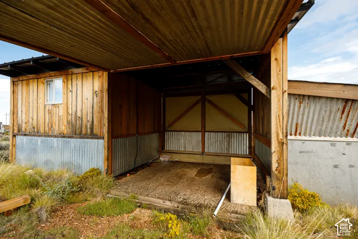 Open-air structure with a corrugated metal roof and wood paneling