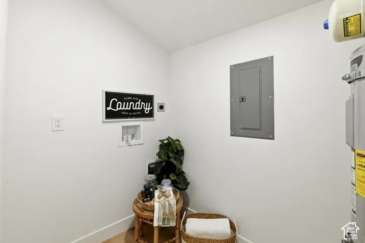 Dedicated utility area featuring a water heater, electrical panel, and appliance hookups