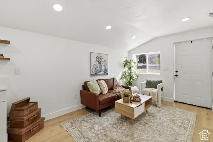 Wood-finish flooring, recessed lighting, and floating shelves