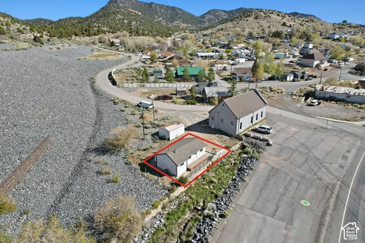 Property featuring a single-story residence with metal roof, positioned on expansive gravel grounds