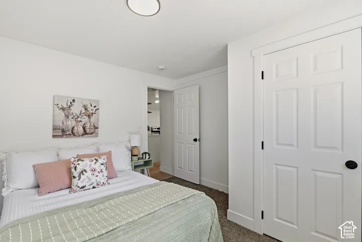 Bright bedroom featuring soft green quilted bedding, coordinating blush accent pillows, and a white six-panel closet door