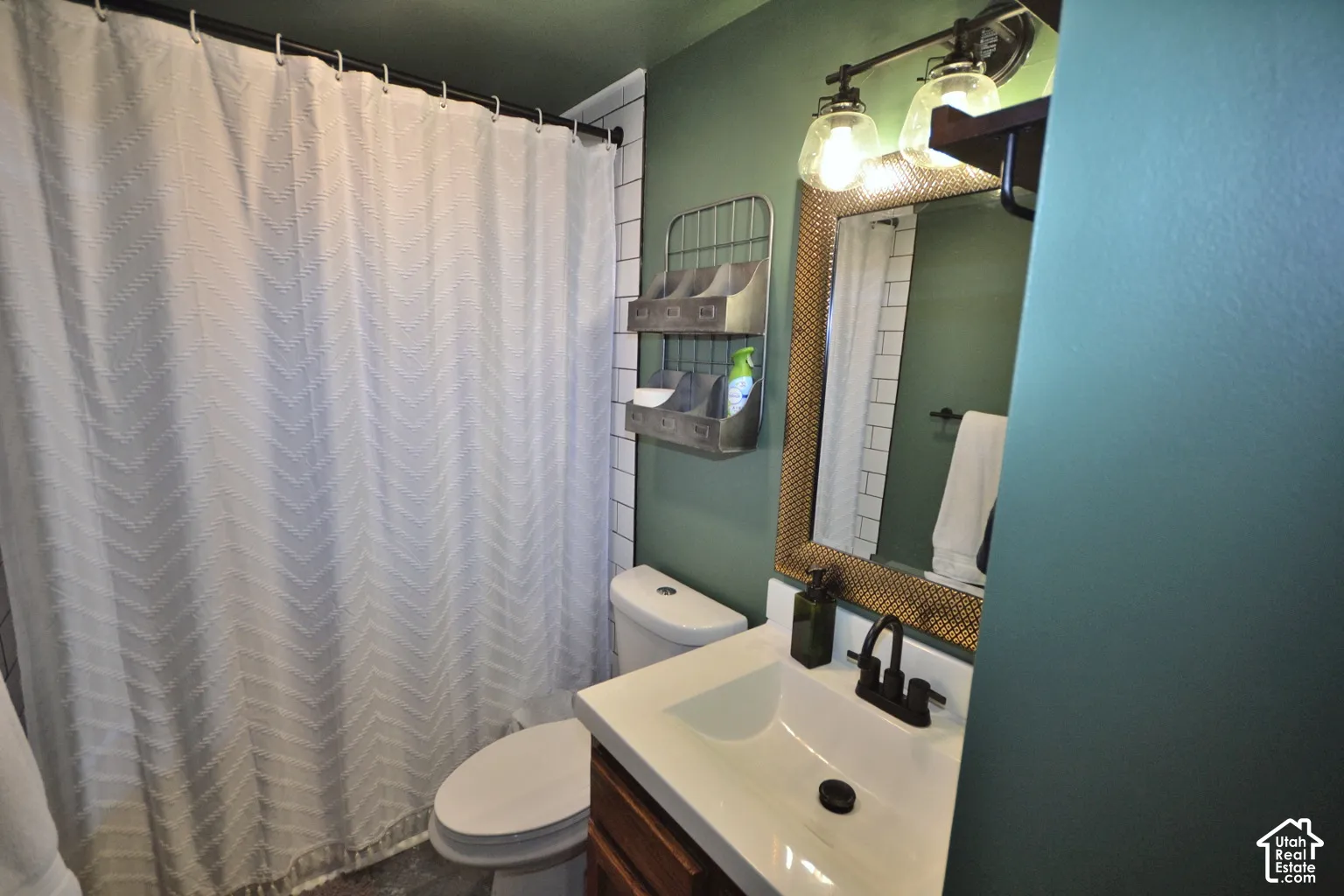 Bathroom featuring a vanity with an integrated sink, dark bronze-finish faucet, and an illuminated mirror