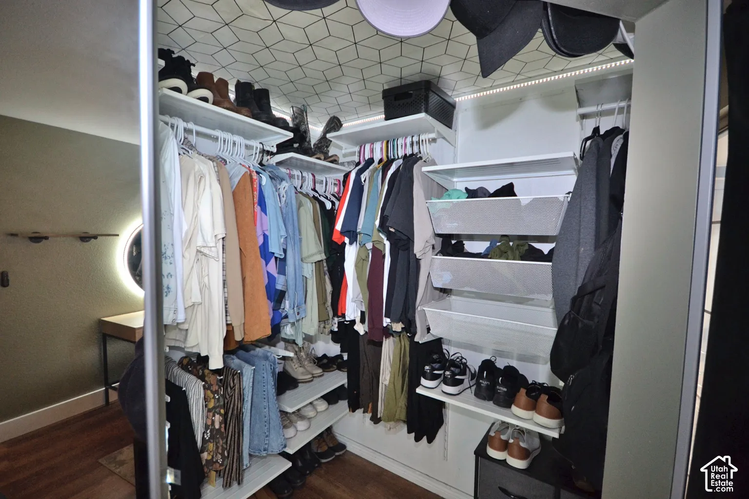 Custom closet system with built-in shelving, hanging rods, and integrated pull-out wire baskets