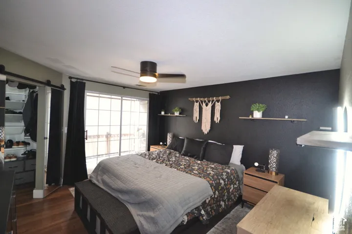 Sliding glass door, wood-finish flooring, ceiling fan, barn door closet, built-in shelving