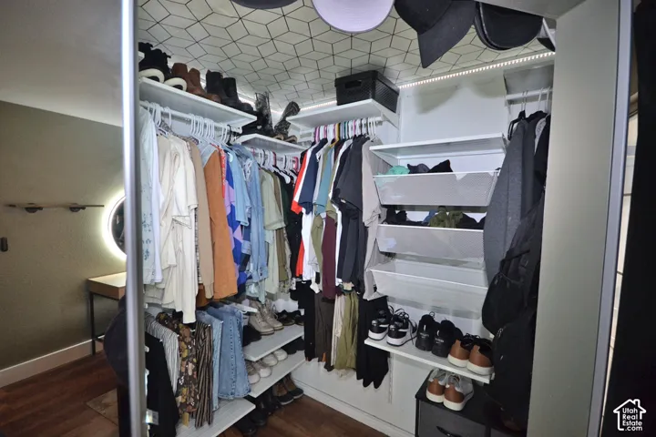 Custom closet system with built-in shelving, hanging rods, and integrated pull-out wire baskets