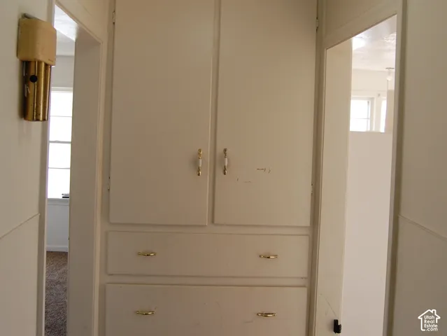 Built-in storage cabinet with multiple drawers and upper cupboards, flush mount ceiling light