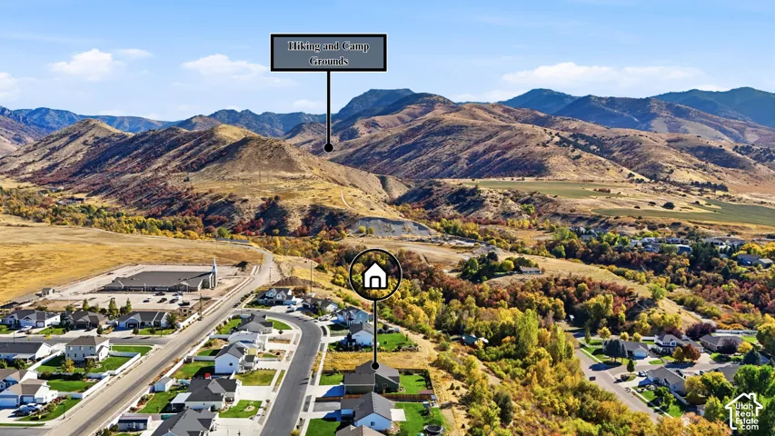 Mountain backdrop, expansive natural landscape, residential community, winding roads, scattered trees
