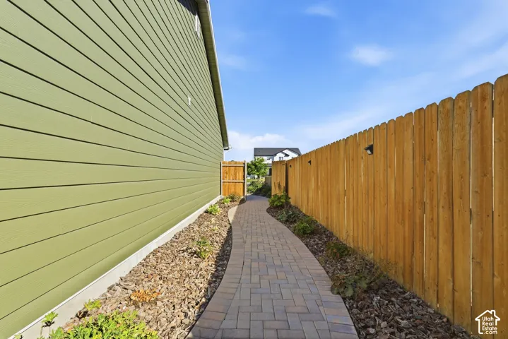 Hardie plank siding, paver pathway, wood privacy fence, decorative landscape bark, and established plantings