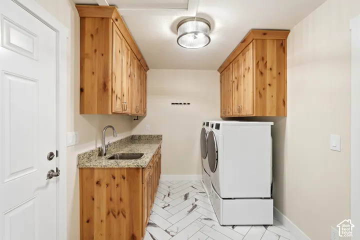 Wood cabinetry with crown molding, light-toned granite countertop, stainless steel utility sink with gooseneck faucet, herringbone-patterned floor tile, and a flush mount light fixture