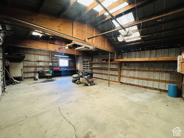 Spacious interior with concrete flooring and exposed wood beam ceiling