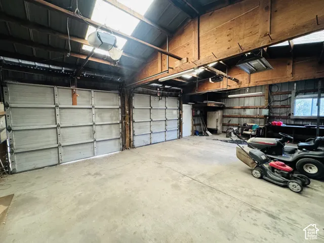 Spacious interior with concrete flooring and exposed wood beam ceiling