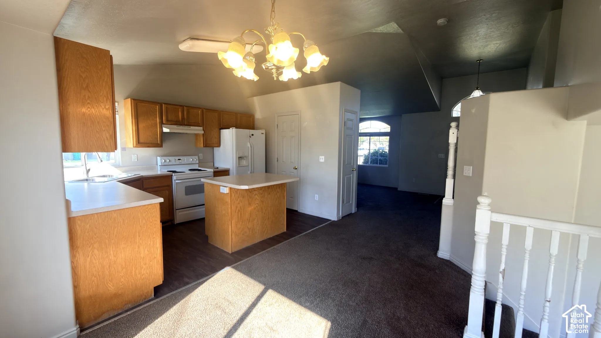 Kitchen featuring wood-finish cabinetry, white countertops, a central island, and wood-finish flooring