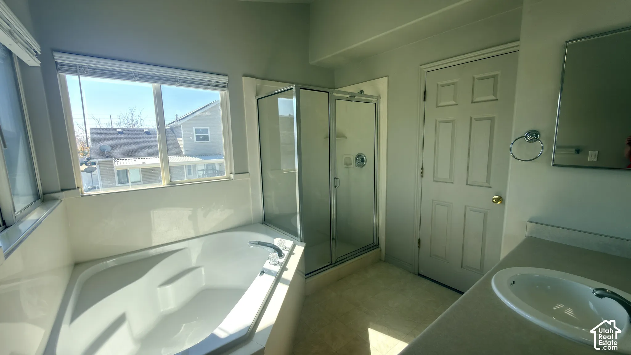 Integrated soaking tub, glass-enclosed shower, single vanity with integrated sink, and panel door