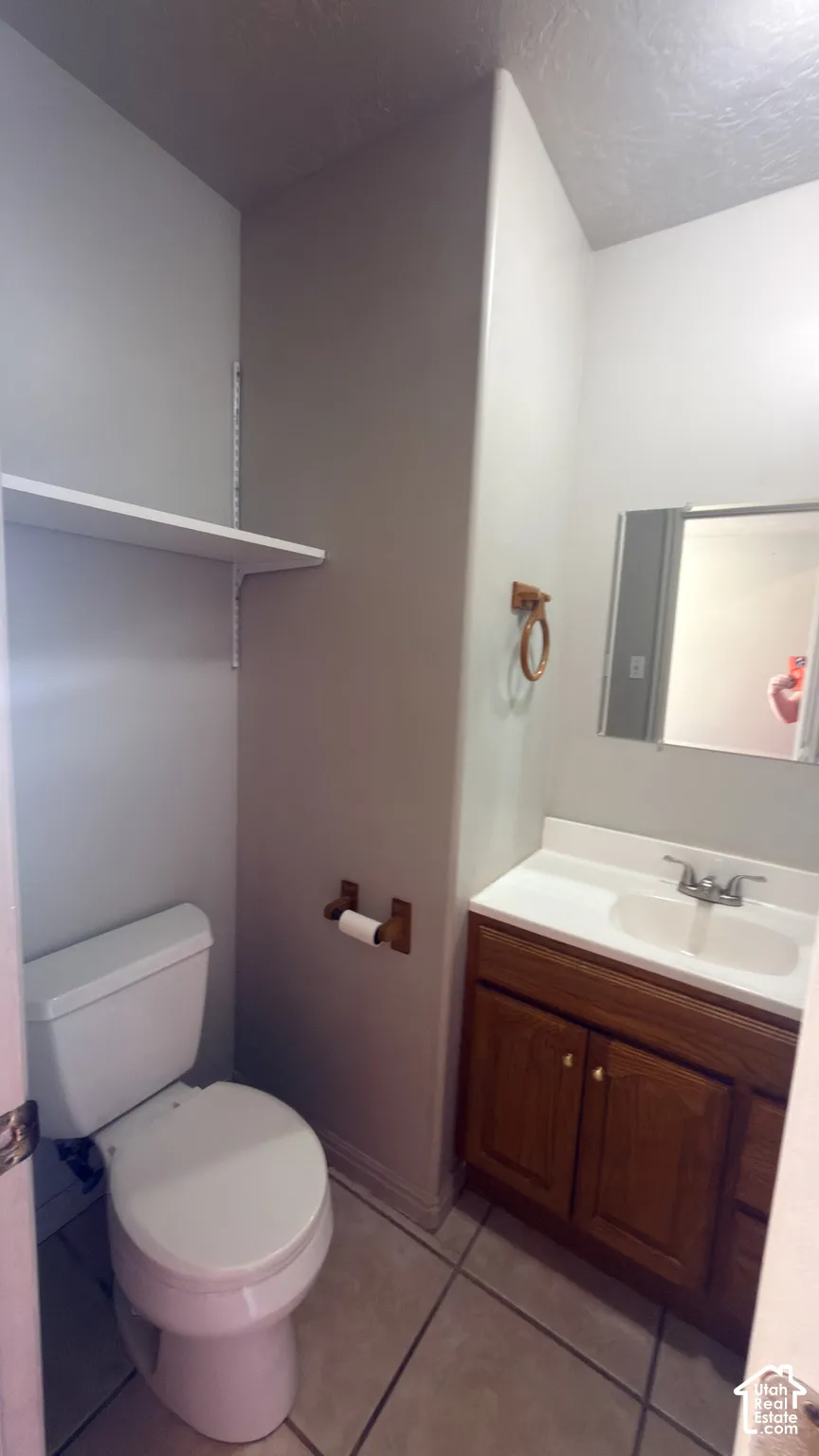 Ceramic tile flooring with a wood-finish vanity and integrated sink