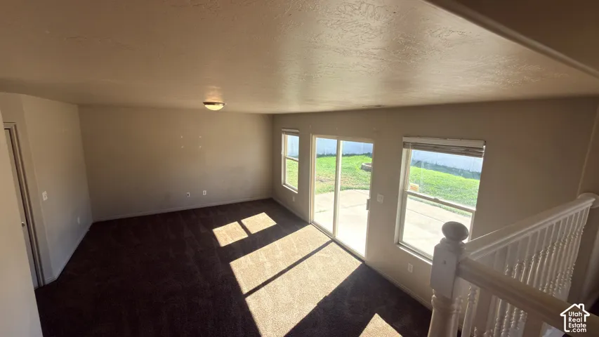 Carpeted interior space with a sliding glass door and an additional window