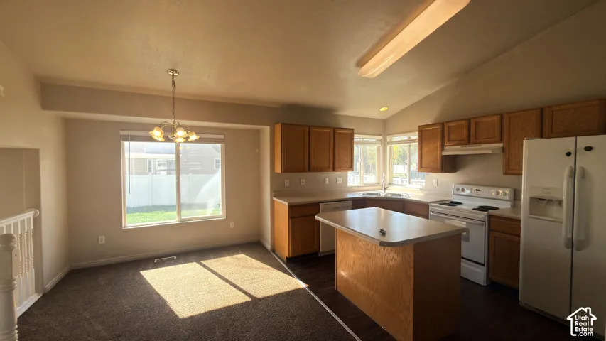 Kitchen and dining area featuring wood-finish cabinetry, white appliances, and a central island