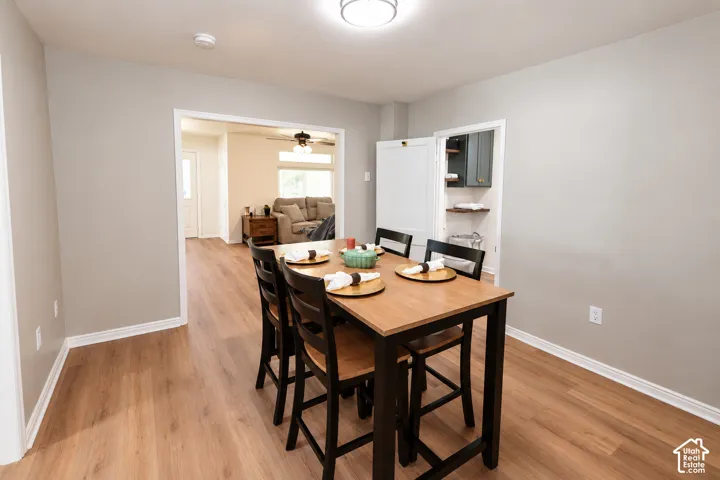 Dining area featuring wood-finish flooring, neutral wall paint, and a reach-in pantry with built-in shelving