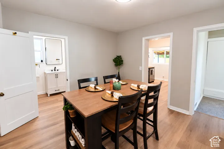 Neutral-toned interior featuring wood-finish flooring, white paneled doors, and a bathroom vanity with a rectangular basin and matte black fixtures