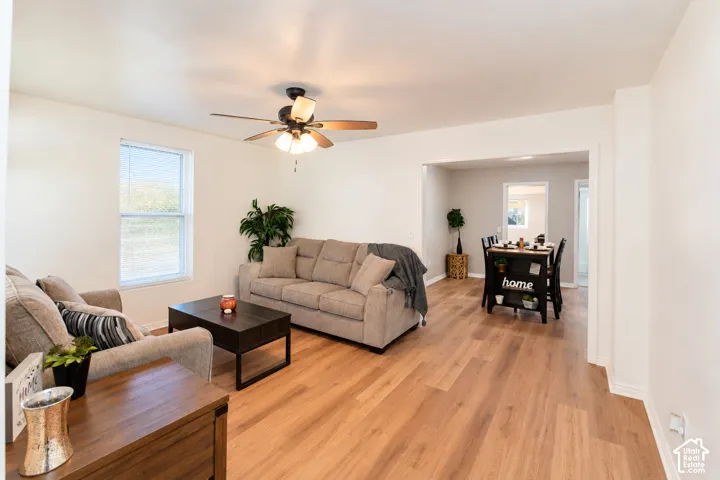 Living area featuring wood-finish flooring, neutral wall paint, and a ceiling-mounted light fixture with a fan
