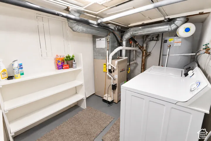 Utility space featuring built-in white shelving, a dedicated furnace, and a water heater