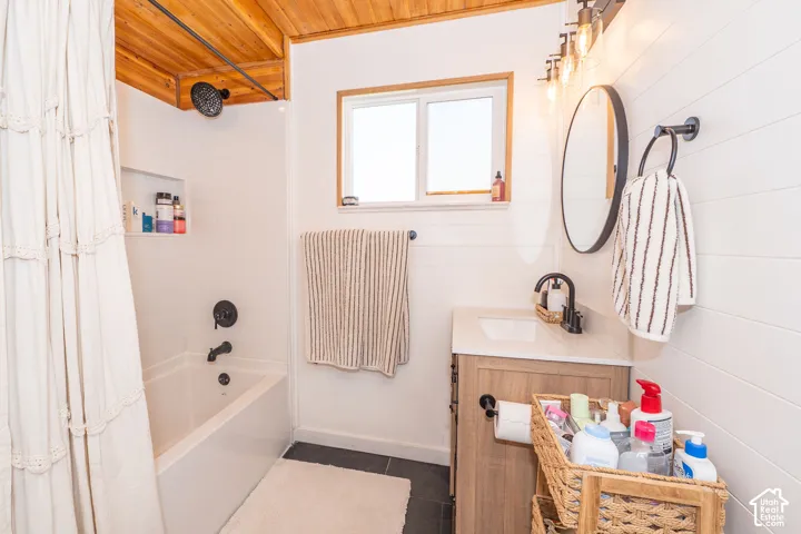 Bathroom featuring a white tub, black fixtures, and a vanity with a light-toned countertop