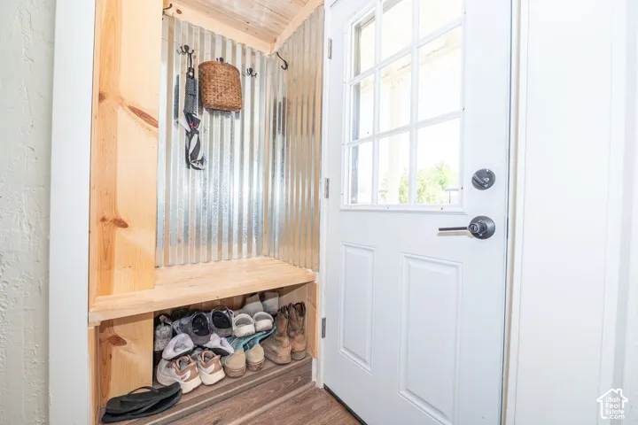 Built-in mudroom bench with wood-finish shelving and corrugated metal paneling