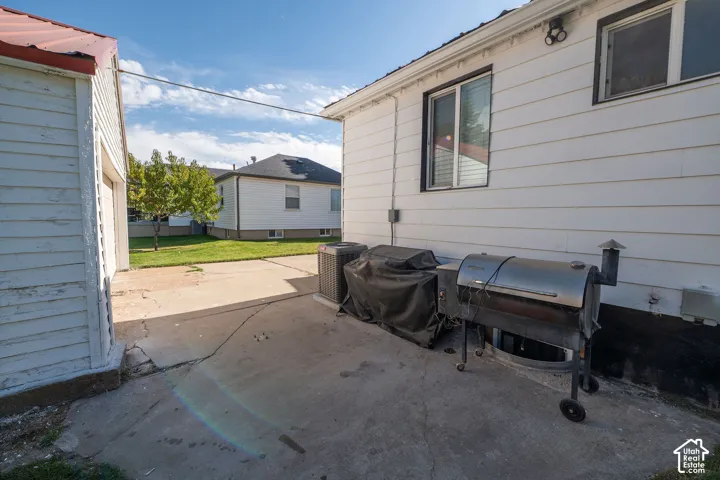Concrete patio with a detached garage and side entrance