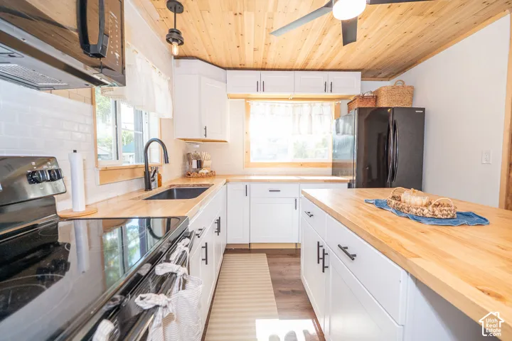 Kitchen featuring a wood-finish ceiling, wood-finish countertops, white shaker-style cabinetry, a built-in electric range, and a built-in refrigerator