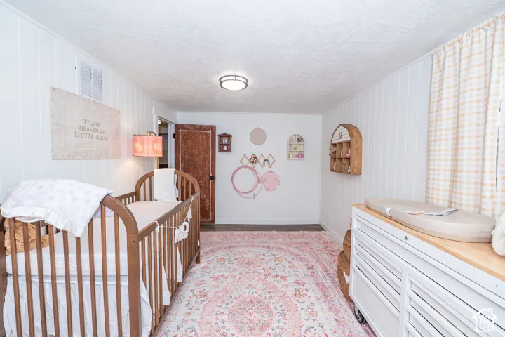 White vertical paneled walls, dark wood-finish flooring, and a flush mount ceiling light fixture