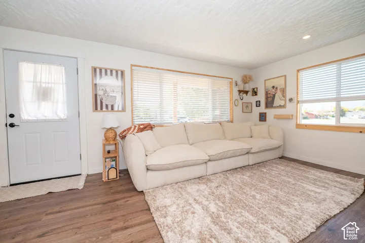Recessed ceiling lighting, wood-finish flooring, white walls, and multiple windows with horizontal blinds