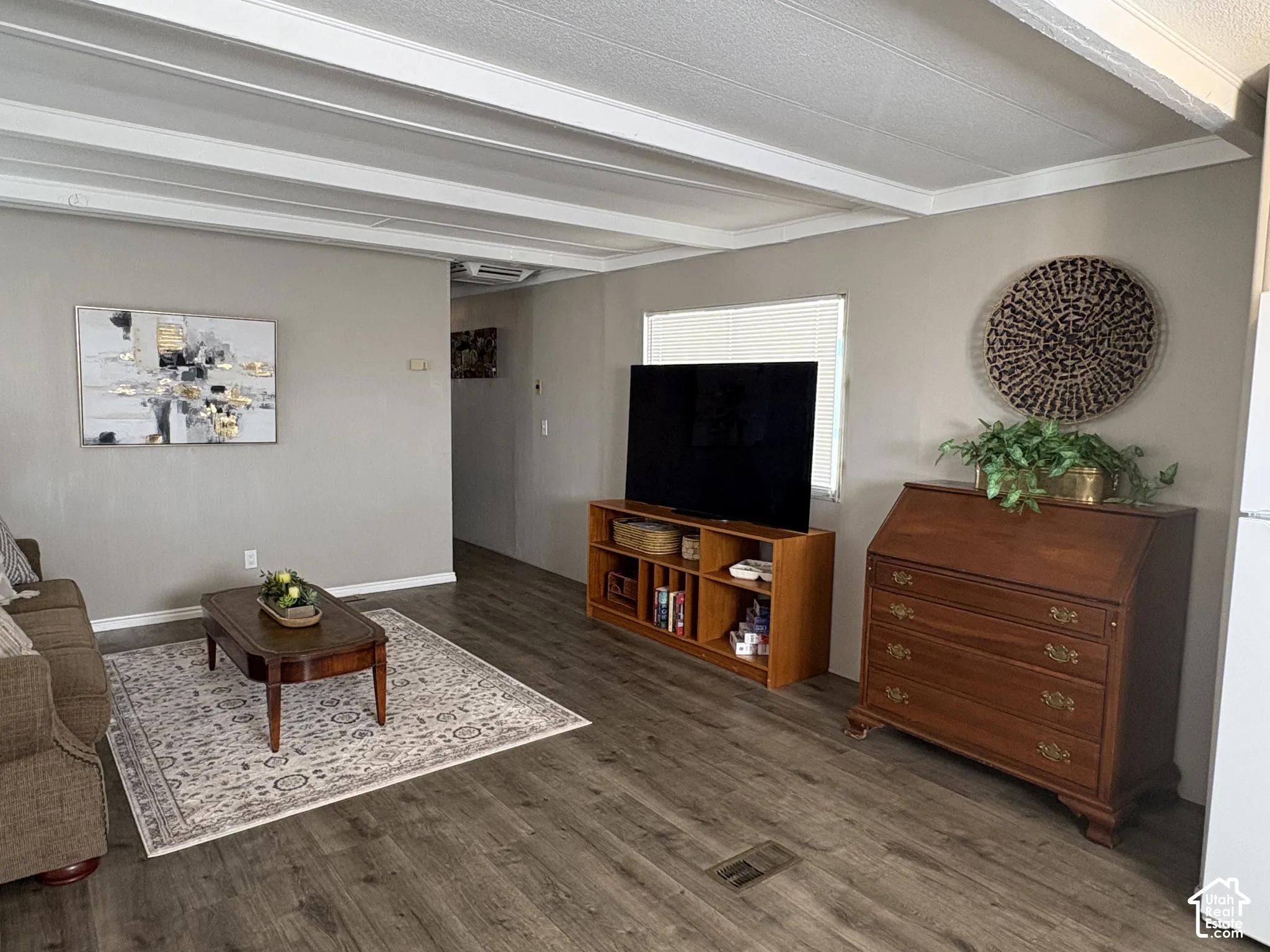 Wood-finish flooring throughout the main living area, complemented by light gray wall tones