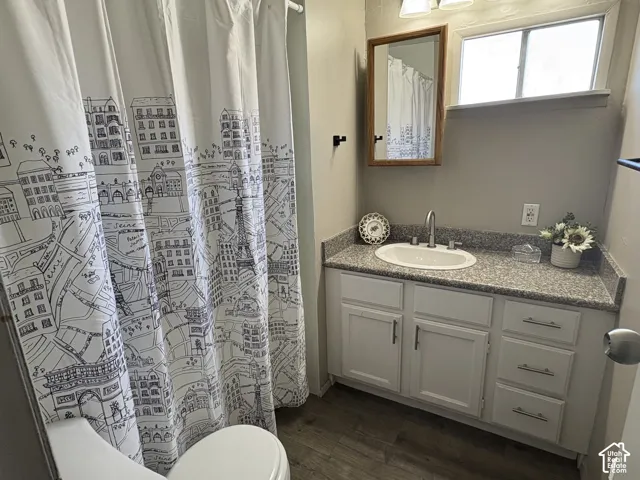 Vanity with integrated sink, granite-finish countertop, and white cabinetry