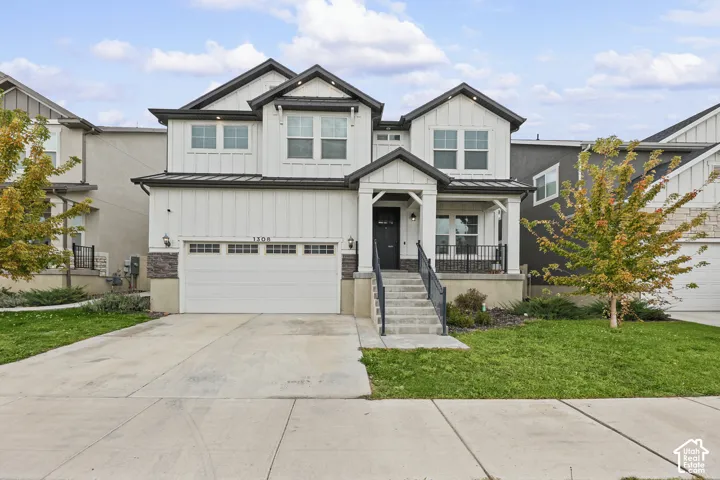 Contemporary two-story exterior with white board and batten siding, dark trim, stone accents, and a covered front porch