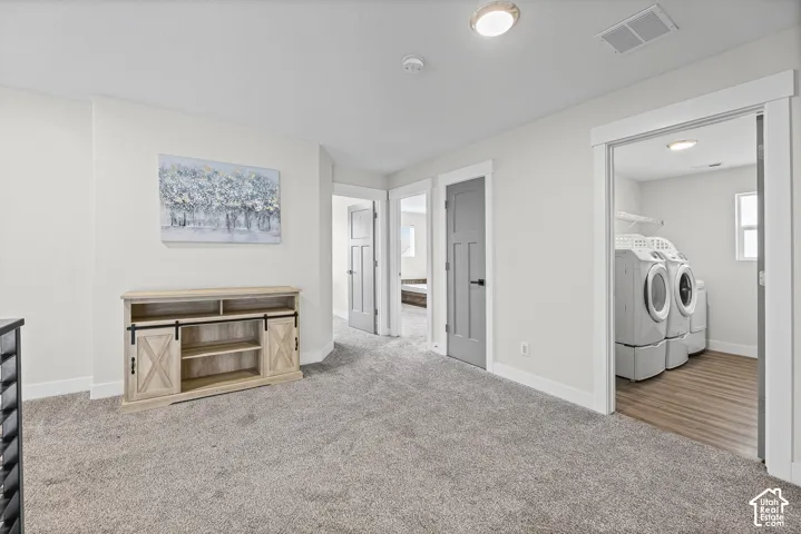 Carpeted flooring, recessed lighting, and a dedicated laundry area with wood-finish flooring