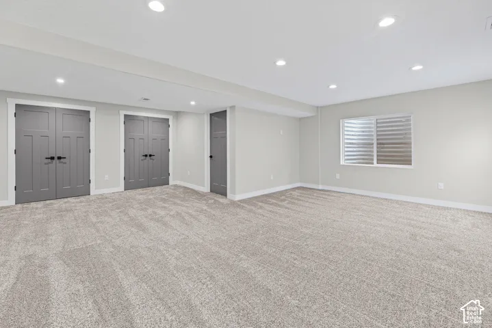Recessed ceiling lighting, light gray wall paint, light-toned carpeting, white window trim, and white baseboards