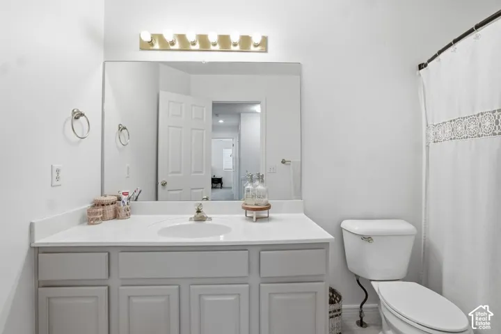 White vanity with integrated sink, chrome faucet, and overhead vanity lighting