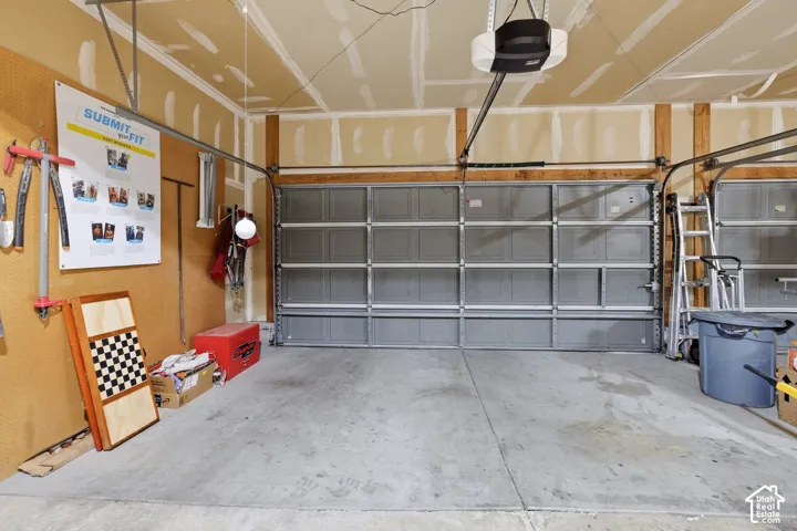 Concrete flooring, exposed wood framing, two overhead garage doors, automatic garage door opener