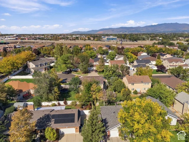 Residential neighborhood setting with mature trees and mountain backdrop