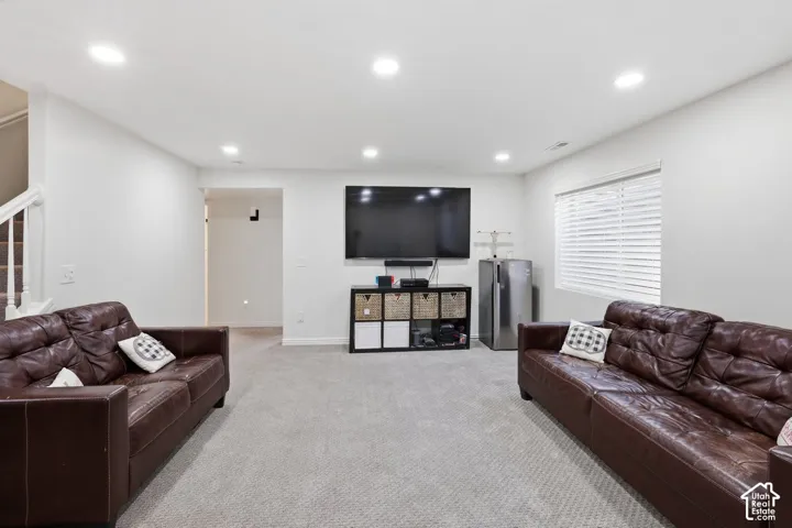 Recessed ceiling lighting, light gray wall paint, carpeted flooring, and a window with blinds