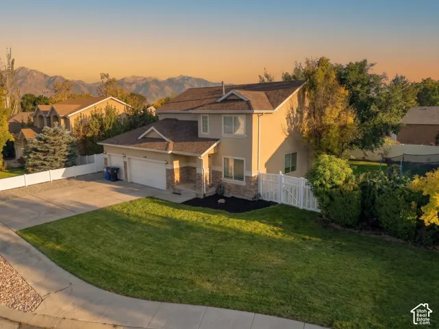 Two-story residence with a stucco and stone veneer exterior, an attached two-car garage, and a concrete driveway