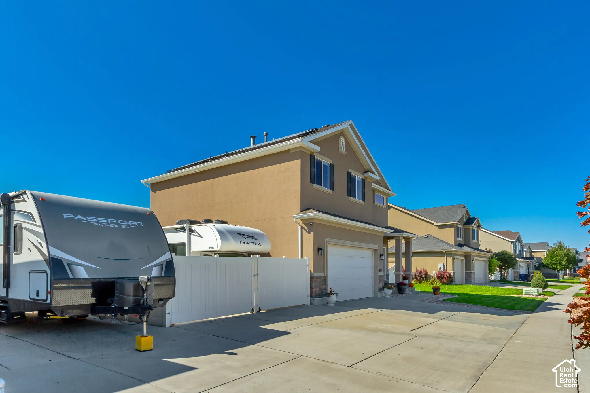 Attached two-story residence featuring a two-car garage, concrete driveway, and stucco exterior