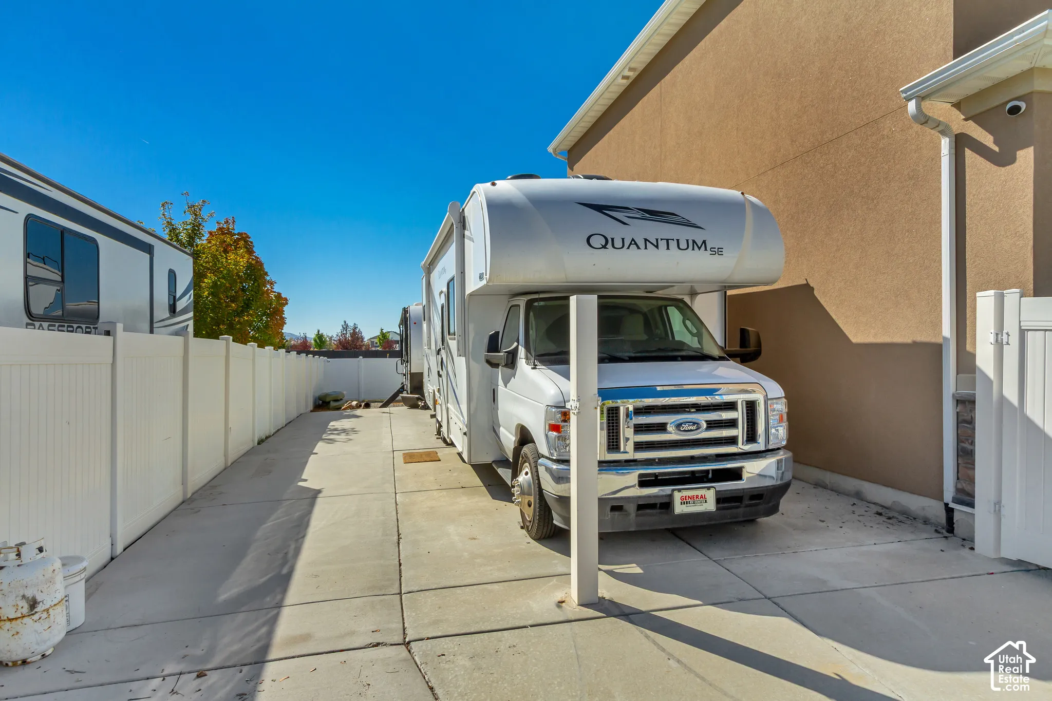 Concrete driveway with white vinyl fencing