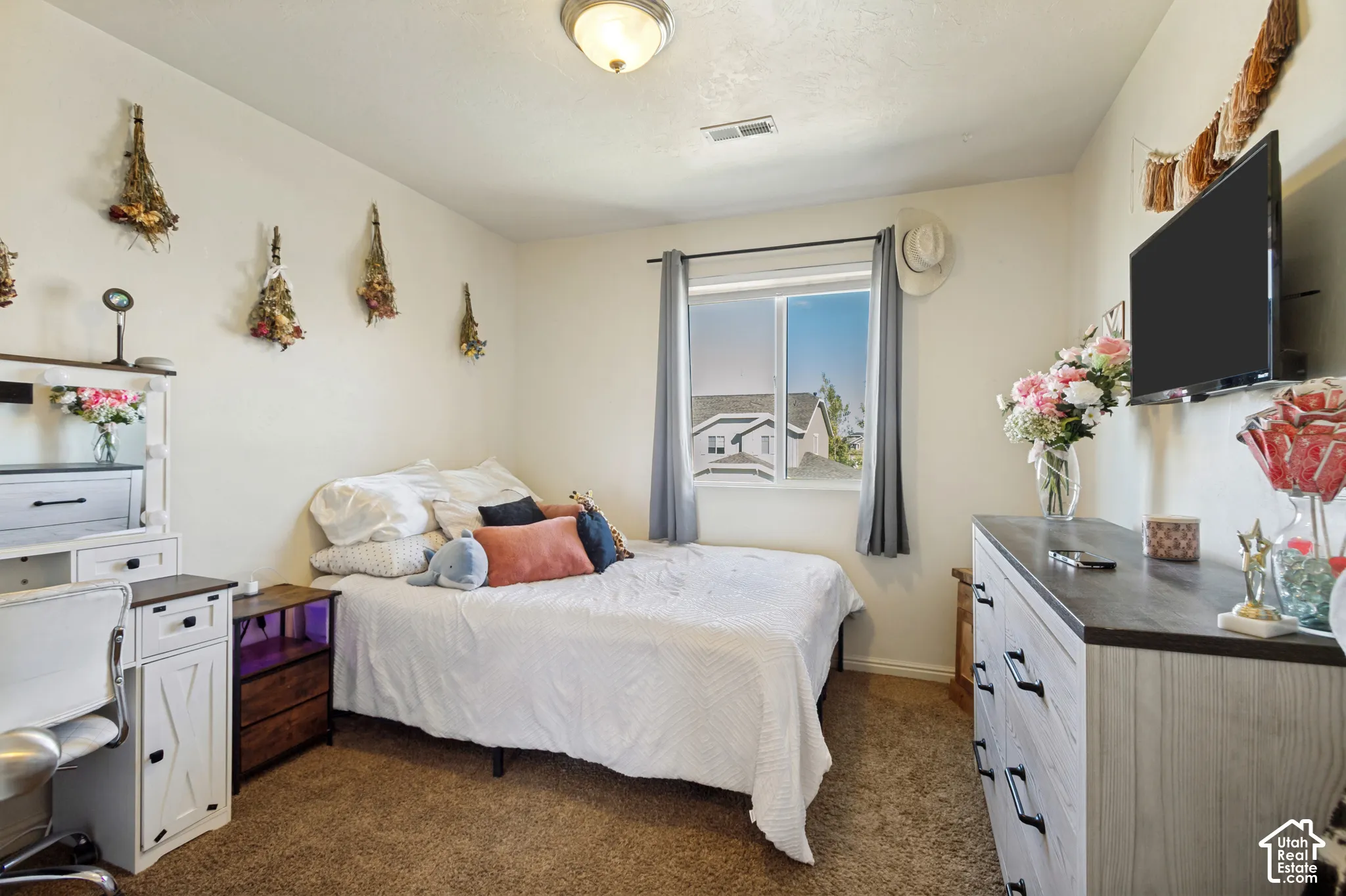 Window with natural light, overhead flush mount light fixture, textured carpeting, painted walls