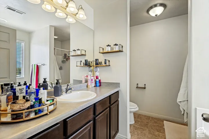 Vanity with integrated sink, dark wood-finish cabinetry, and a full-width mirror
