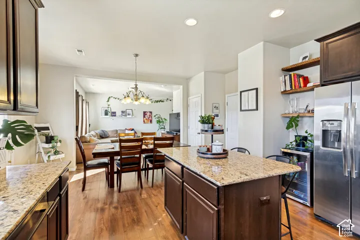 Spacious kitchen featuring granite countertops, wood-finish flooring, and dark wood cabinetry
